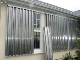 Wilmington home secured with metal hurricane panels - american hurricane shutters Wilmington home protected by metal hurricane panels.