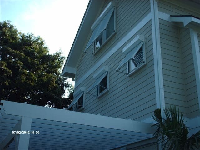 Topsail beach house with protective hurricane shutters - american hurricane shutters Topsail Beach house with louvered hurricane shutters and white pergola.