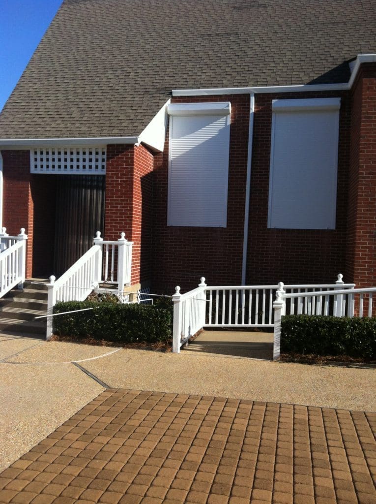 Community building: white hurricane shutters, carolina coast - american hurricane shutters Coastal brick community building with white hurricane shutters.