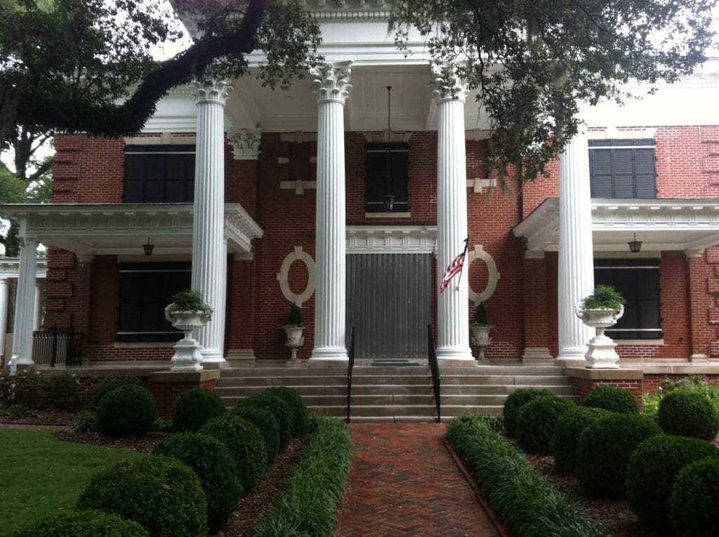 Stately carolina brick mansion - american hurricane shutters Stately Carolina red brick mansion featuring white columns.