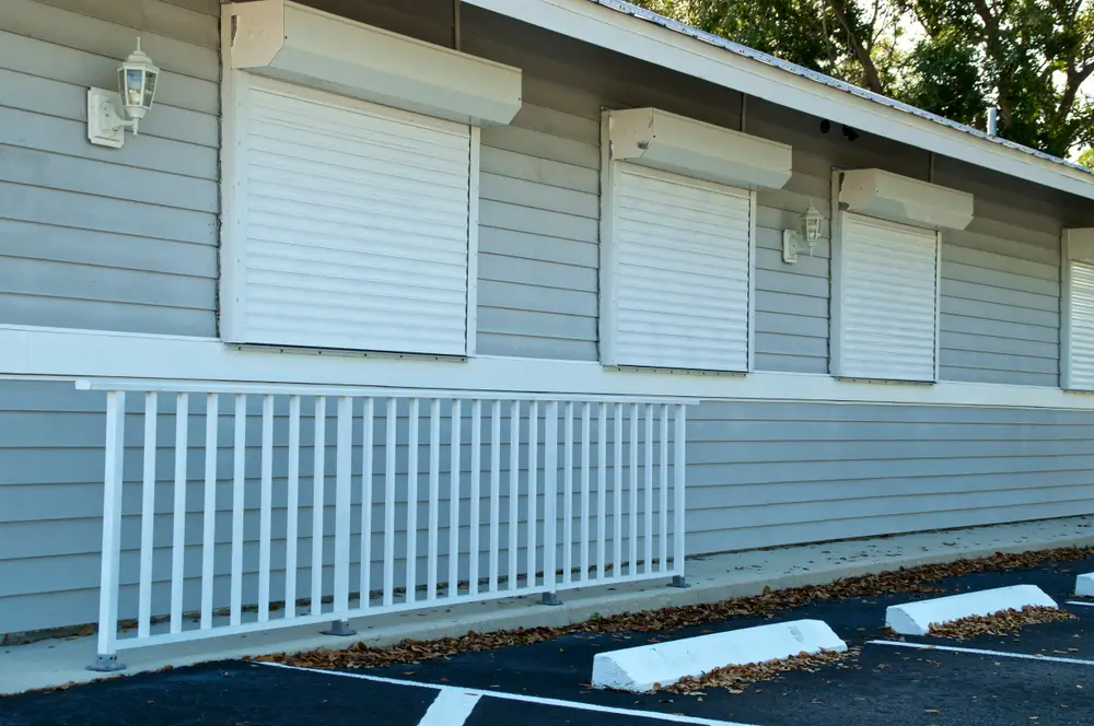 Hurricane shutters installed on windows of a residential building in New Bern, North Carolina, showcasing storm protection solutions for homeowners.