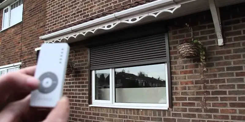 Remote control rolldown hurricane shutters, wilmington - american hurricane shutters Mans hands remotely control smart roller hurricane shutters.