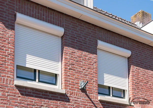 White hurricane roller shutters on red brick building.